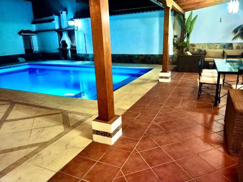 La CodoseraCasa Rural Los Olmos的游泳池位于带桌椅的房间