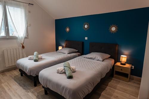 Saint Avre la ChambreEscapade Mauriennaise的蓝色墙壁客房的两张床
