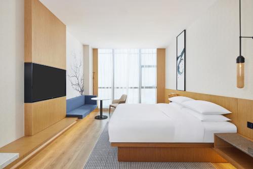 淄博淄博万枫酒店的一间酒店客房,配有一张床和一台电视