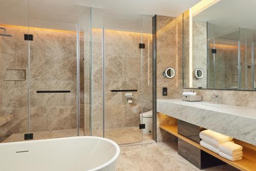 淄博淄博万枫酒店的一间带浴缸和淋浴的浴室