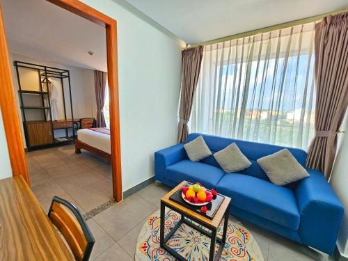 金边Le Botum Hotel的客厅设有蓝色的沙发和窗户。