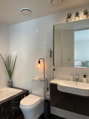 金斯顿Lakeview Luxe - EV charger, Pool, Gym, Location +的一间带卫生间、水槽和镜子的浴室