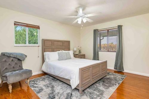 波因顿海滩4/3.5 House with pool- Boynton Beach, FL.的一间卧室配有一张床、风扇和椅子
