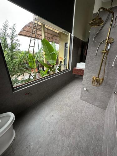邦美蜀Ylang Farmstay的带淋浴和卫生间的浴室以及窗户。