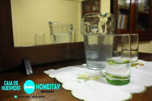 马塔加尔帕Homestay Matagalpa的镜子前桌子上坐着一杯水