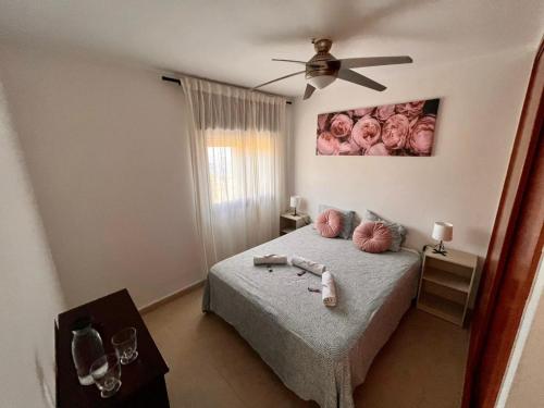 拉斯卡萨斯Casa La Asomada El Hierro的一间卧室配有一张带吊扇的床