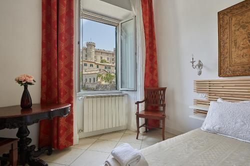 布拉恰诺LE CAMERE di VITTORIA的一间卧室设有窗户,享有建筑的景色