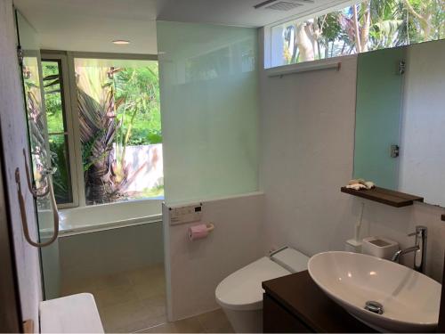 石垣岛727セブンツーセブン石垣島ベース的一间带水槽和卫生间的浴室以及窗户。