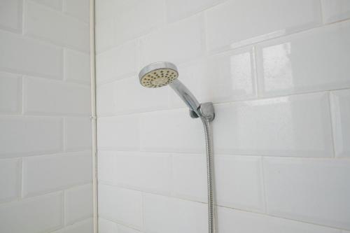 马卡萨RedDoorz at Golden White House Pettarani的浴室内配有淋浴和头顶淋浴