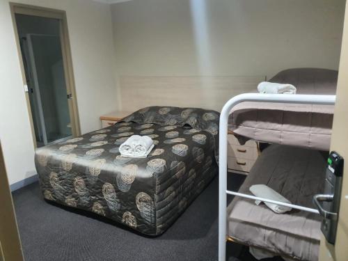 KambahKambah Inn的小房间设有一张床和一张双层床
