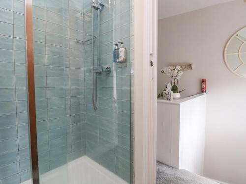 康威Millgate Cottage的浴室设有蓝色瓷砖淋浴。