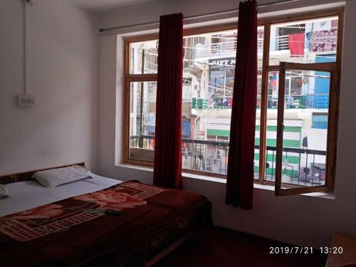 卡尔吉尔OYO Holidayinn的一间卧室设有一张床和两个窗户。