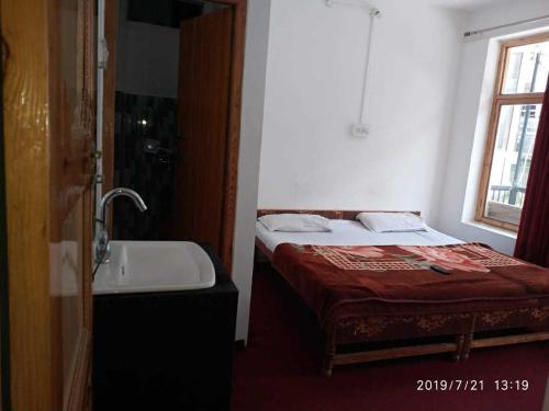 卡尔吉尔OYO Holidayinn的一间带床和水槽的小卧室