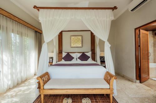 克拉玛斯Desa Swan Villas & SPA, Keramas的一间卧室配有一张带天蓬的白色床