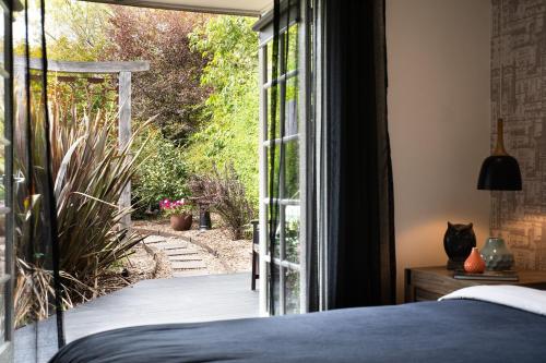 戴尔斯福特East Street Datlesford的卧室设有滑动玻璃门,享有花园的景色