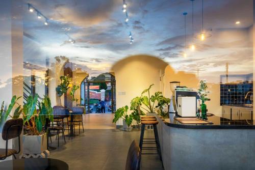 大叻Meek - Home and Coffee的一间在房间的墙上种植植物的餐厅