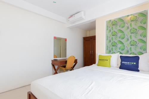 泗水Urbanview Erga Family Residence Syariah Surabaya的一间卧室配有白色的床和蓝色和黄色枕头
