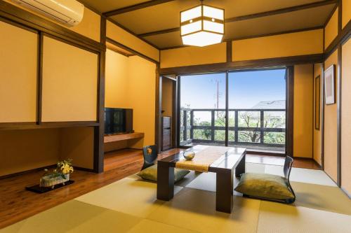 伊东料理の宿　伊豆の花的客厅设有桌子和大窗户