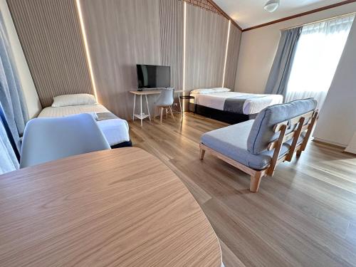 莫里旅游Spa酒店的酒店客房,配有两张床、椅子和桌子