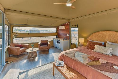 BroadwaterWillow Wood Glamping Retreat的一间卧室设有一张床和一间客厅。