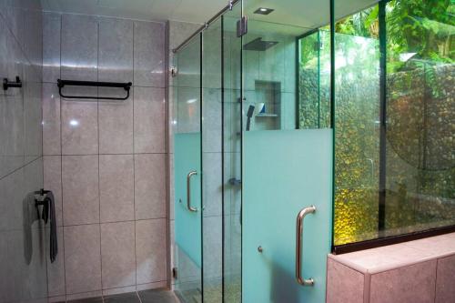 Kampung Sunjai GapoiZen Forest Entire Villa with Private Pool at Karak的带淋浴的浴室和玻璃门