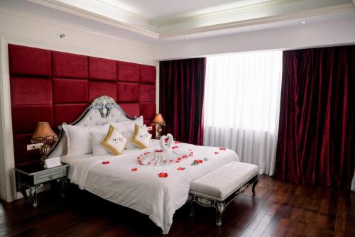 顺化月光顺酒店的一间卧室配有一张大床和红色床头板