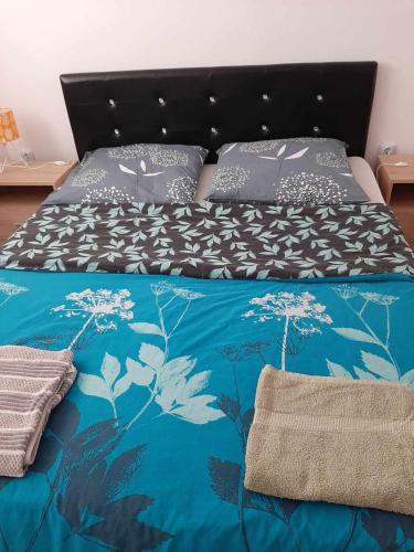 WieprzSzary Domek 2的一张带蓝色被子和枕头的床