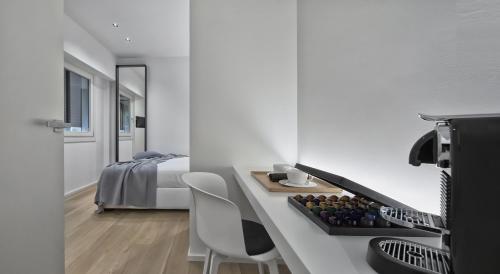 里乔内Luxury Suites Collection - SHANTUNG Double Room的白色的客房配有一张床、一张桌子和椅子