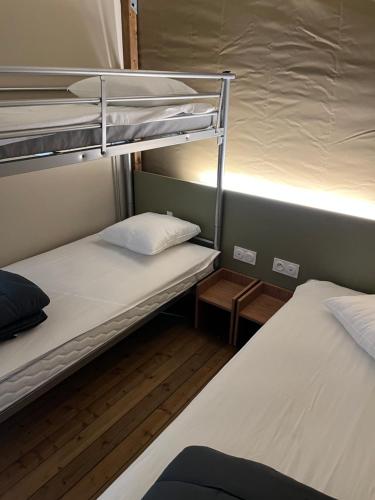 塞内UCPA Eco Lodge的小型客房配有两张双层床和灯具。