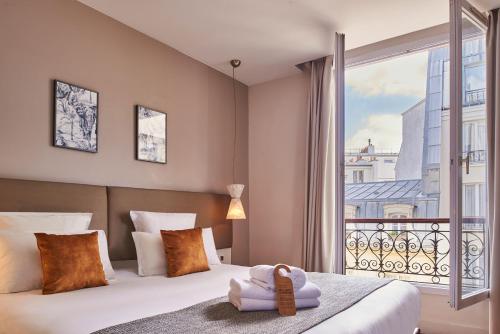 巴黎快乐文化马真塔38酒店的一间卧室设有一张床和一个大窗户