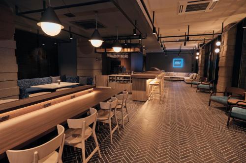 高山FAV LUX Hida Takayama的餐厅内的酒吧配有椅子和柜台
