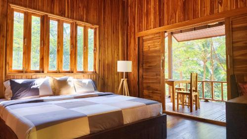 帕干岛Baan Bhuwann Forest Chalet的一间卧室设有一张床和一个大窗户