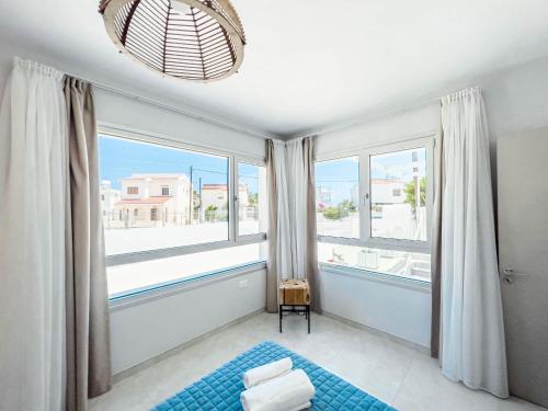 普罗塔拉斯Geo Panoramic Villa +Pool +Game Room +Gym的卧室设有大窗户和蓝色地毯。