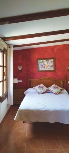 丘利利亚Refugio La Presa的卧室配有白色的床铺和红色的墙壁