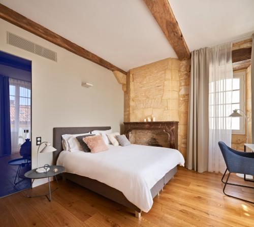 蒙帕齐耶hideauts hotels Le Chevalier bleu的一间卧室设有一张大床和一个壁炉