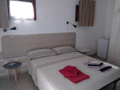 诺沃利B&B Villa Sofia的卧室配有白色床和红色毛巾
