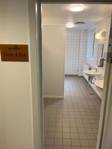 布勒鲁普Assersbølgård的浴室设有卫生间,门上标有不好的标牌