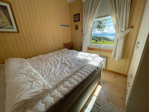 莫尔德Sjarmerende hytte omgitt av vakker natur的卧室配有白色的床和窗户