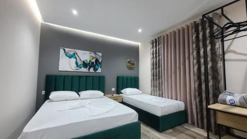 都拉斯Guest House Tian & Hojz的一间卧室设有两张床和窗户。