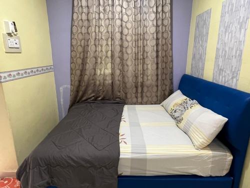 巴力拉惹Ayem Homestay UTHM的一张带蓝色床头板和窗帘的小床