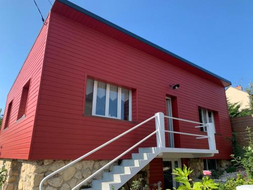 滨海图维列La Maison Rouge的一座红色的房子,有楼梯通往