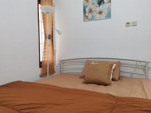 日惹Ambarukmo Green Hill / MA 8的卧室内的一张带两个枕头的床