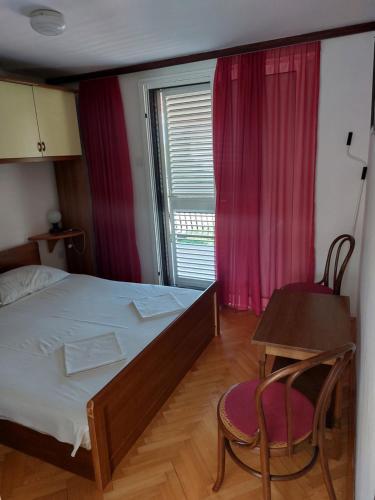 扎达尔波日克公寓酒店的一间卧室配有一张床、一张桌子和一个窗户。