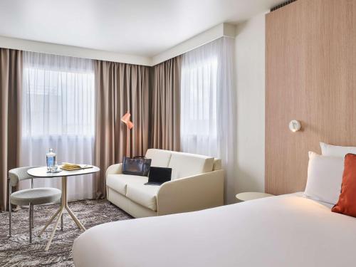 莱克朗兰比塞特尔巴黎诺富特酒店 - 13 Porte d'Italie的酒店客房配有床、沙发和椅子