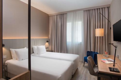 的里雅斯特NH特里斯特酒店的酒店客房配有两张床和一张书桌