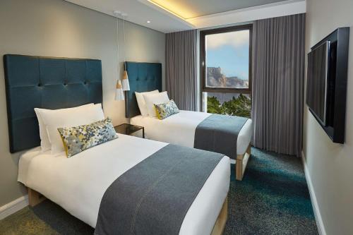 开普敦StayEasy Cape Town City Bowl的酒店客房设有两张床和电视。