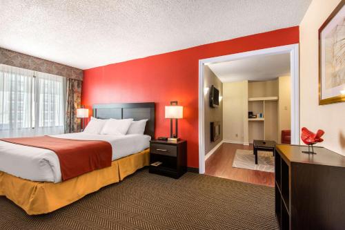 米西索加多伦多西部迪克西401品质套房酒店的酒店客房,设有一张红色墙壁的床