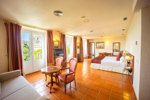 圣洛伦索-德埃斯科里亚尔佛罗里达酒店的酒店客房带一张床、一张桌子和椅子