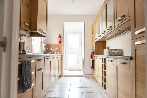 普里茅斯Fred's Place的厨房配有木制橱柜和瓷砖地板。