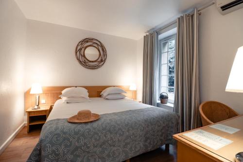 尼姆普利伽罗弗里酒店的一间卧室,配有一张床,上面有帽子